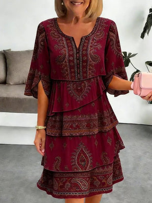 Burgundy paisley print tiered mini dress with split flutter sleeves and V-neck.