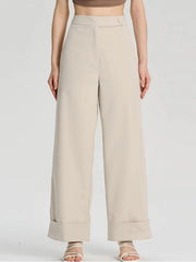 Beige wide-leg tailored trousers with cuffed hemline and button detail.