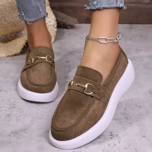 Brown suede loafers with gold horse-bit detail and white soles.