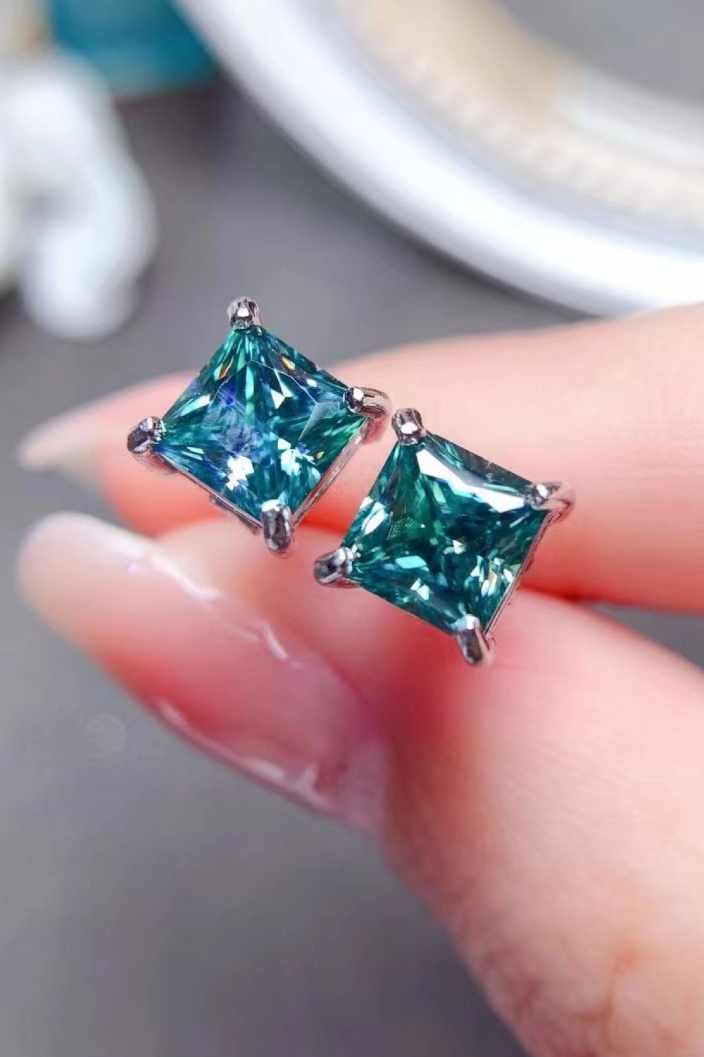 Emerald cut stud earrings in green with silver setting