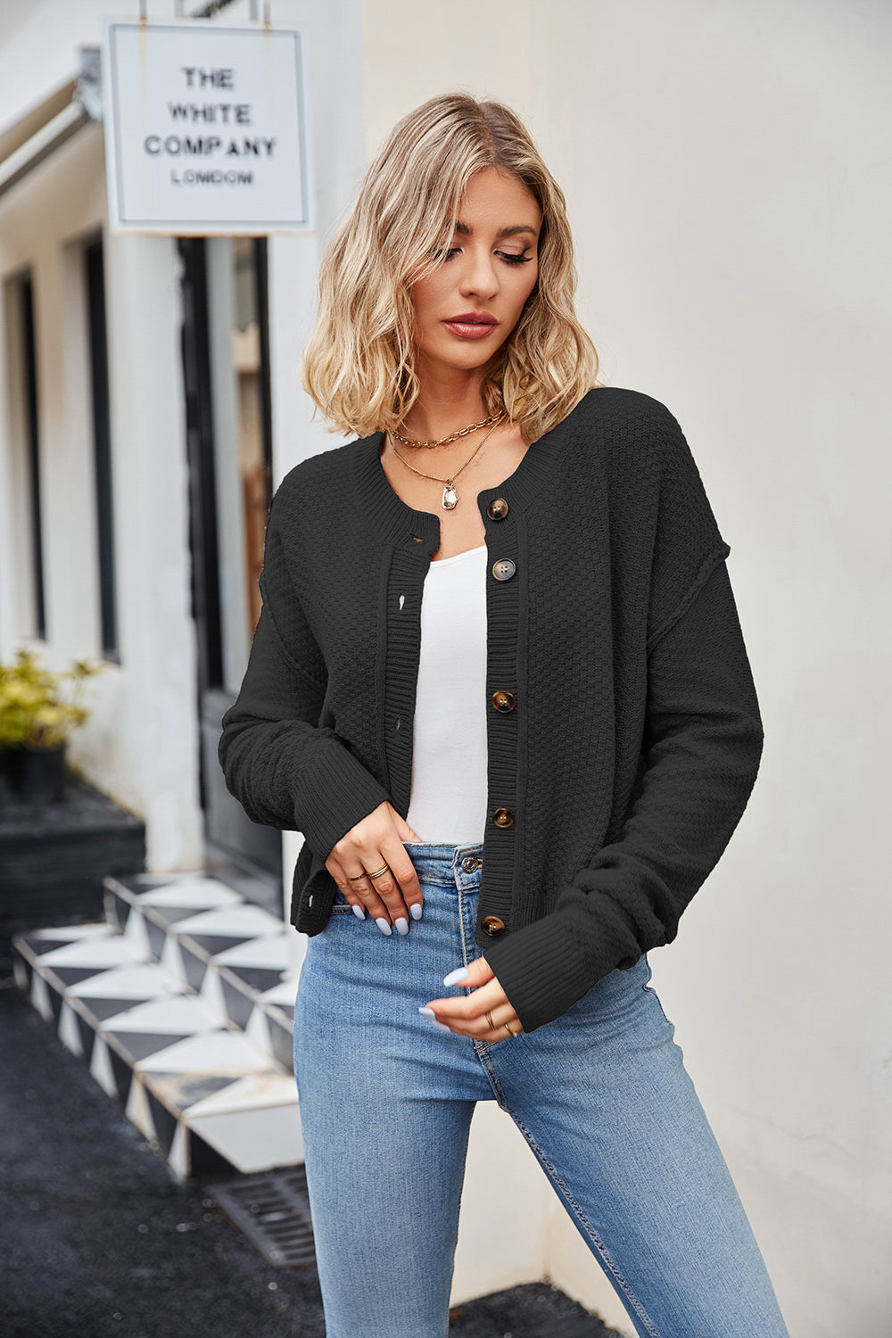 Black textured knit cropped cardigan with button front and round neckline.