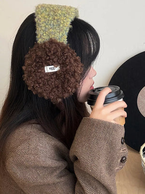 Plush sherpa earmuffs with textured green headband and brown earcups.