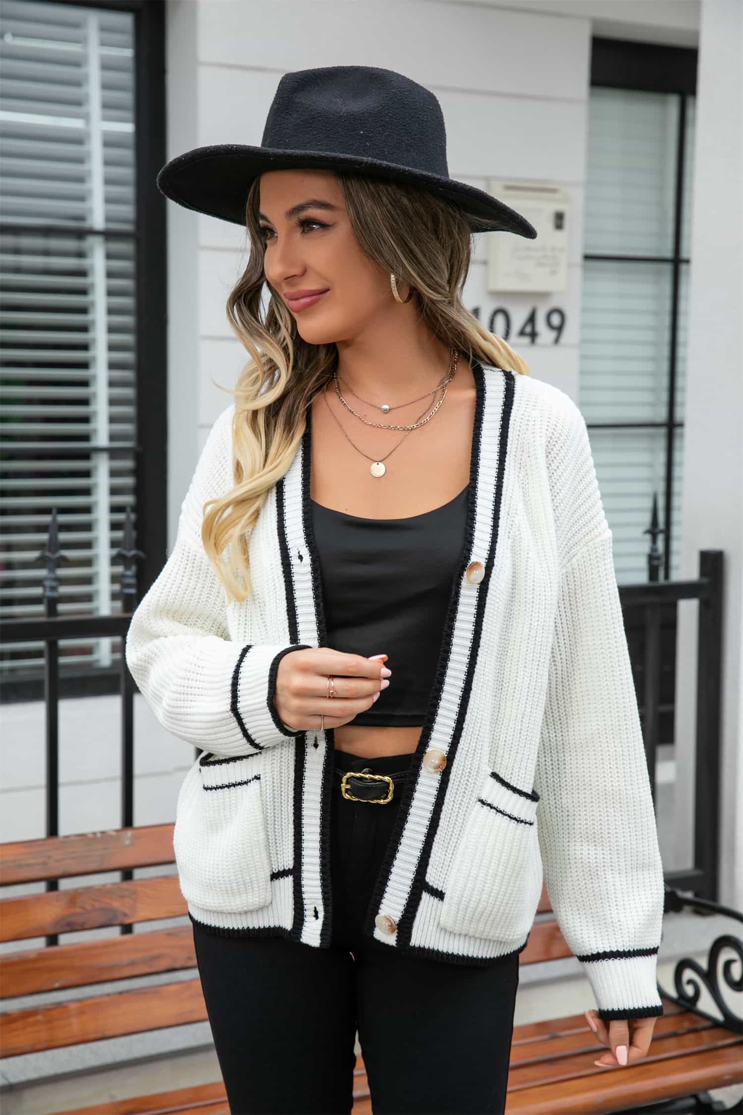 White acrylic cardigan with black trim and pockets, button front, V-neck