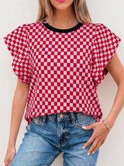 Red and white checkered print shirt with ruffle sleeves and black neckline.