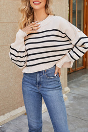 Boxy ribbed knit sweater in beige with black stripes, crew neck, and long sleeves.