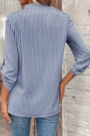 Dark blue and white striped V-neck blouse with rolled sleeves and a pocket detail.