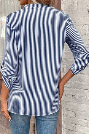 Dark blue and white striped V-neck blouse with rolled sleeves and a pocket detail.