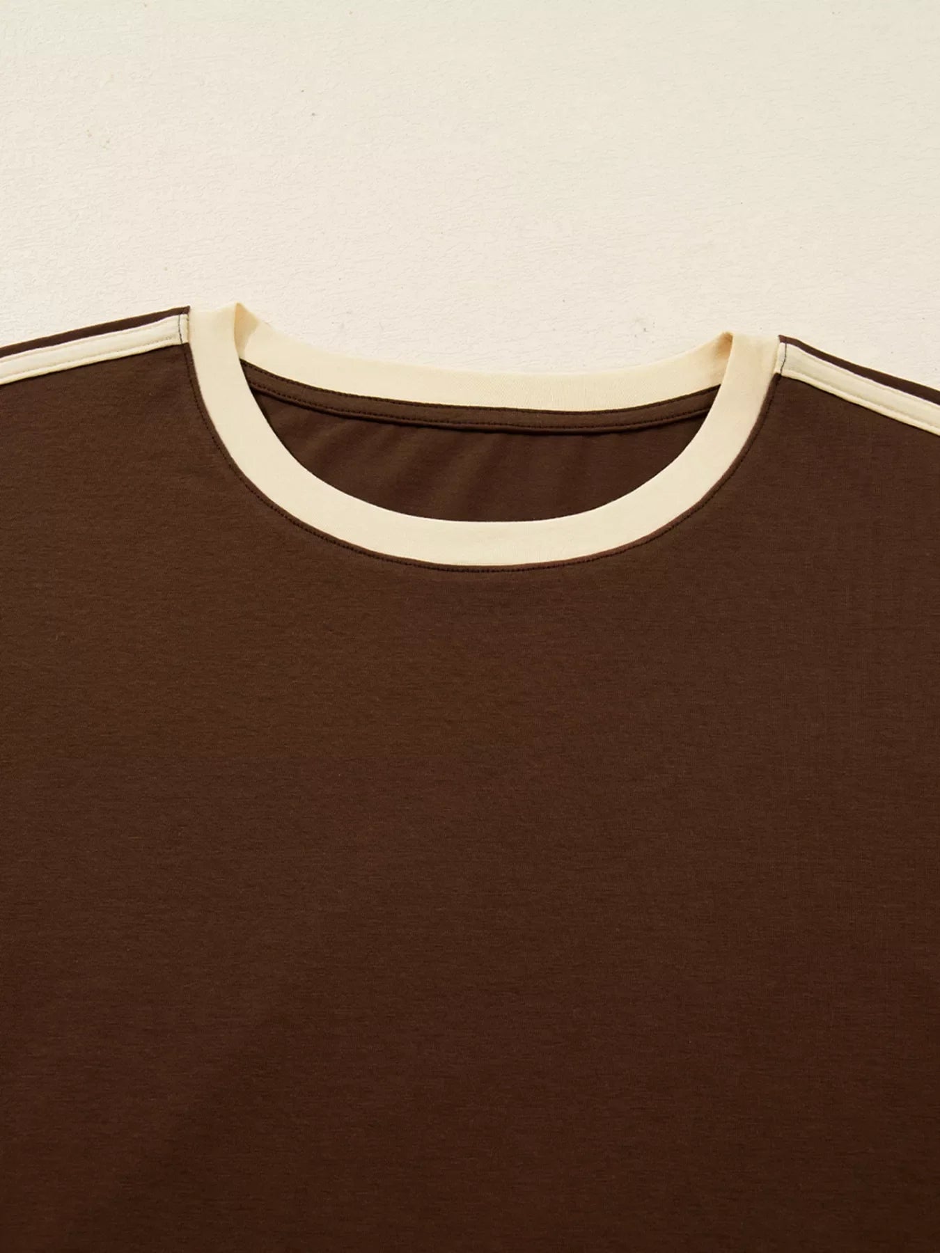 Dark brown long-sleeve t-shirt with contrast cream neckline and sleeve stripes.