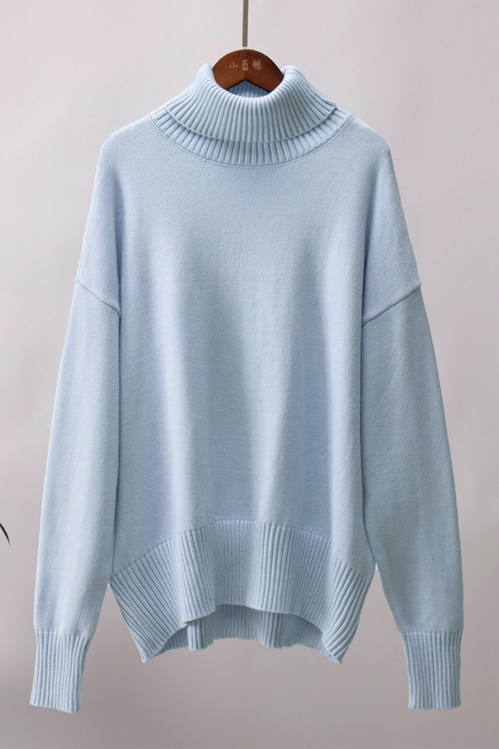 Misty Blue relaxed fit knit sweater with a cozy roll-neck and ribbed details.