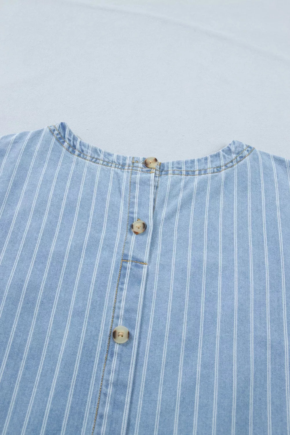 Denim mini dress with vertical white pinstripes and button front detail.