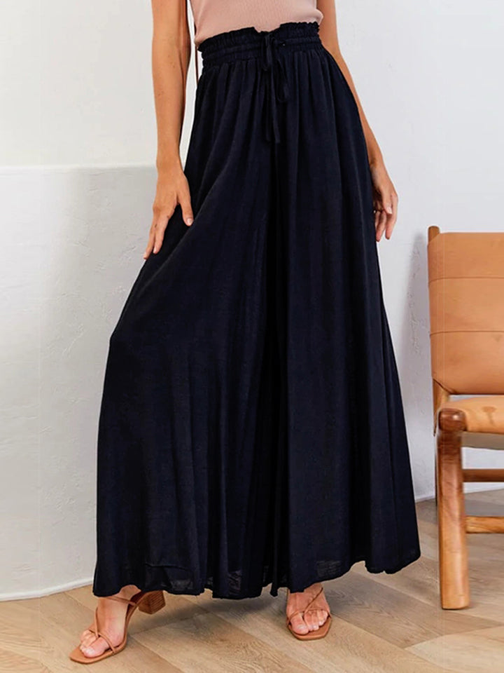 Black polyurethane palazzo pants with gathered waist and drawstring detail.