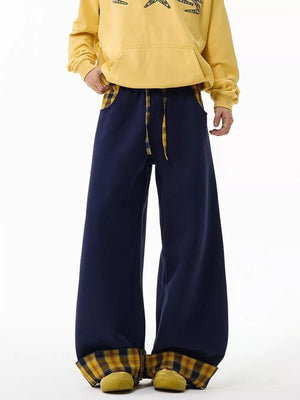 Navy blue wide-leg sweatpants with drawstring and plaid accents.