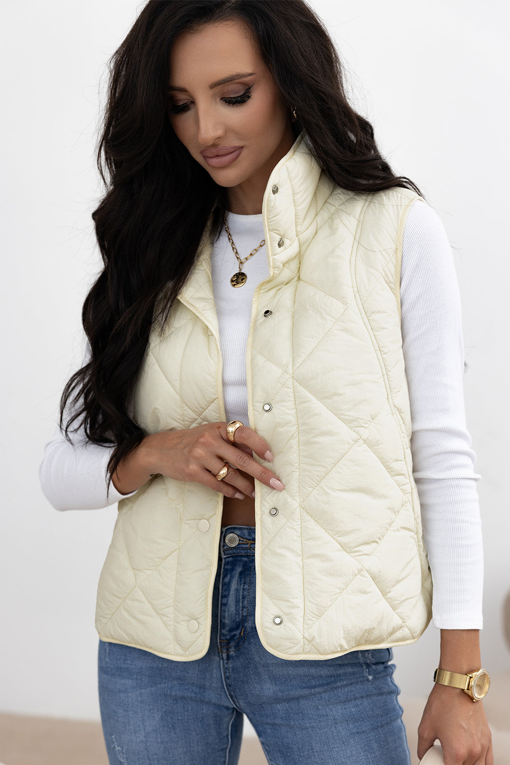 Ivory quilted stand collar vest with snap front closure and diamond pattern.
