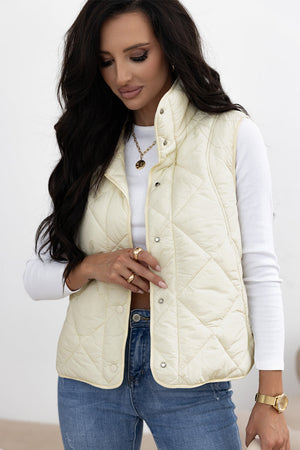 Ivory quilted stand collar vest with snap front closure and diamond pattern.