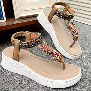 Ethnic patterned wedge sandals in khaki with floral accents and ankle straps.