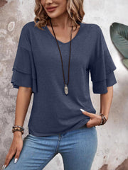 Indigo tiered sleeve jersey tee with V-neck, styled with jeans and necklace.