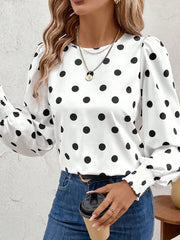 White polka dot blouse with smocked cuffs and puff sleeves.