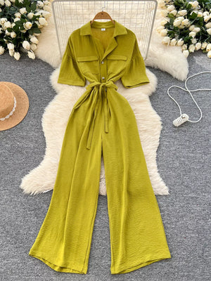 Belted wide-leg jumpsuit in green with pockets and short sleeves.