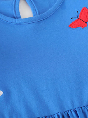 Blue cotton baby dress with red butterfly applique and ruffle hem.