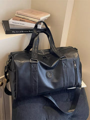 Black pu leather duffel bag with dual handles and a detachable shoulder strap.