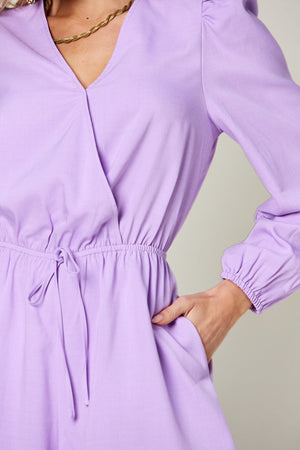 Lavender wrap front romper with puff sleeves, adjustable waist tie, and cinched cuffs.