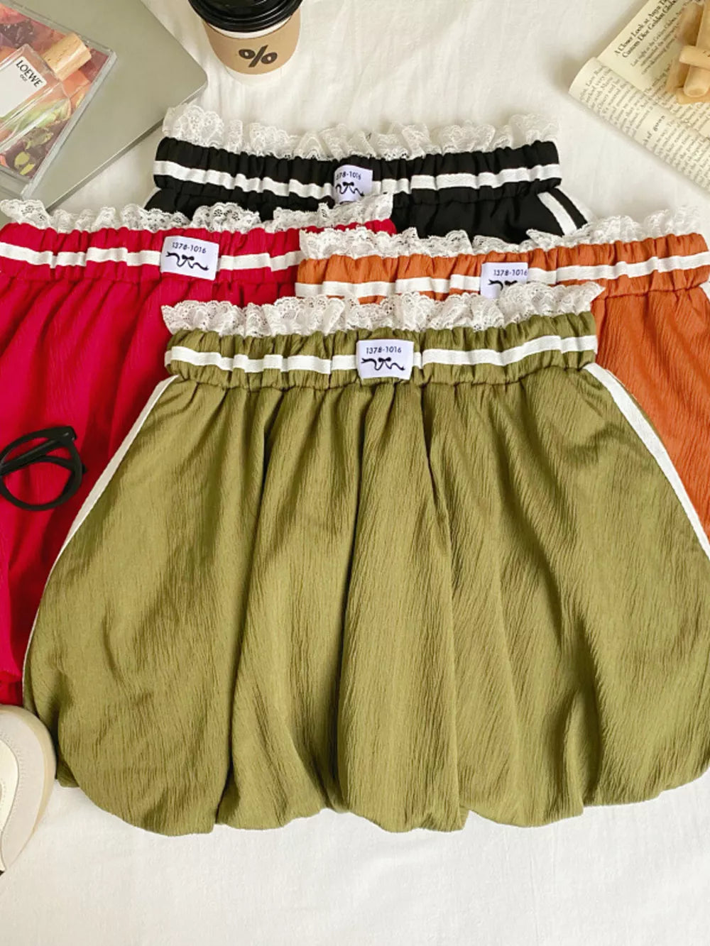 Gathered waist mini skirts in red, army green, orange, and black with lace trim and stripe detail.