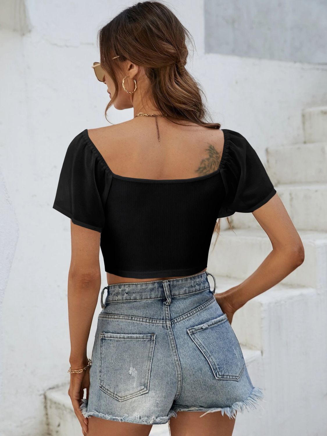 Black ribbed crop top with chiffon puff sleeves and square neckline.