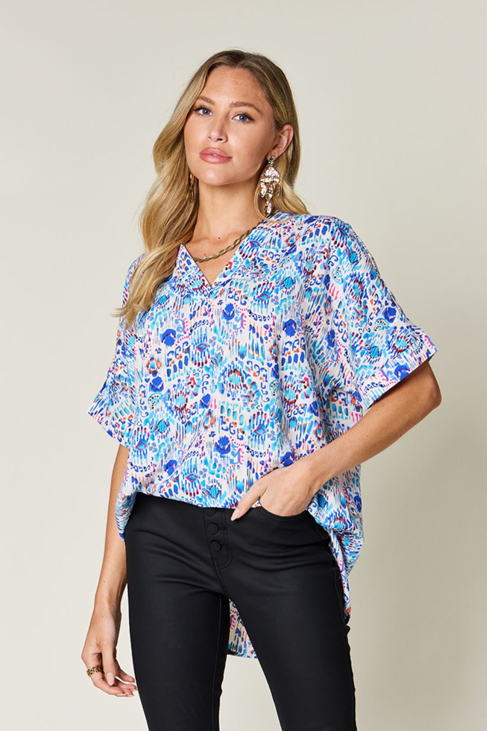 Floral ikat relaxed v-neck blouse with short sleeves in pink and sky blue.