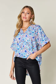 Floral ikat relaxed v-neck blouse with short sleeves in pink and sky blue.
