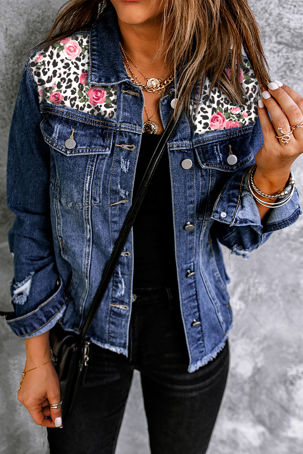 Denim trucker jacket with leopard floral patches and distressed details.