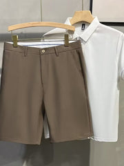 Men's brown chino shorts with a button and zip fly, shown with a white polo shirt.