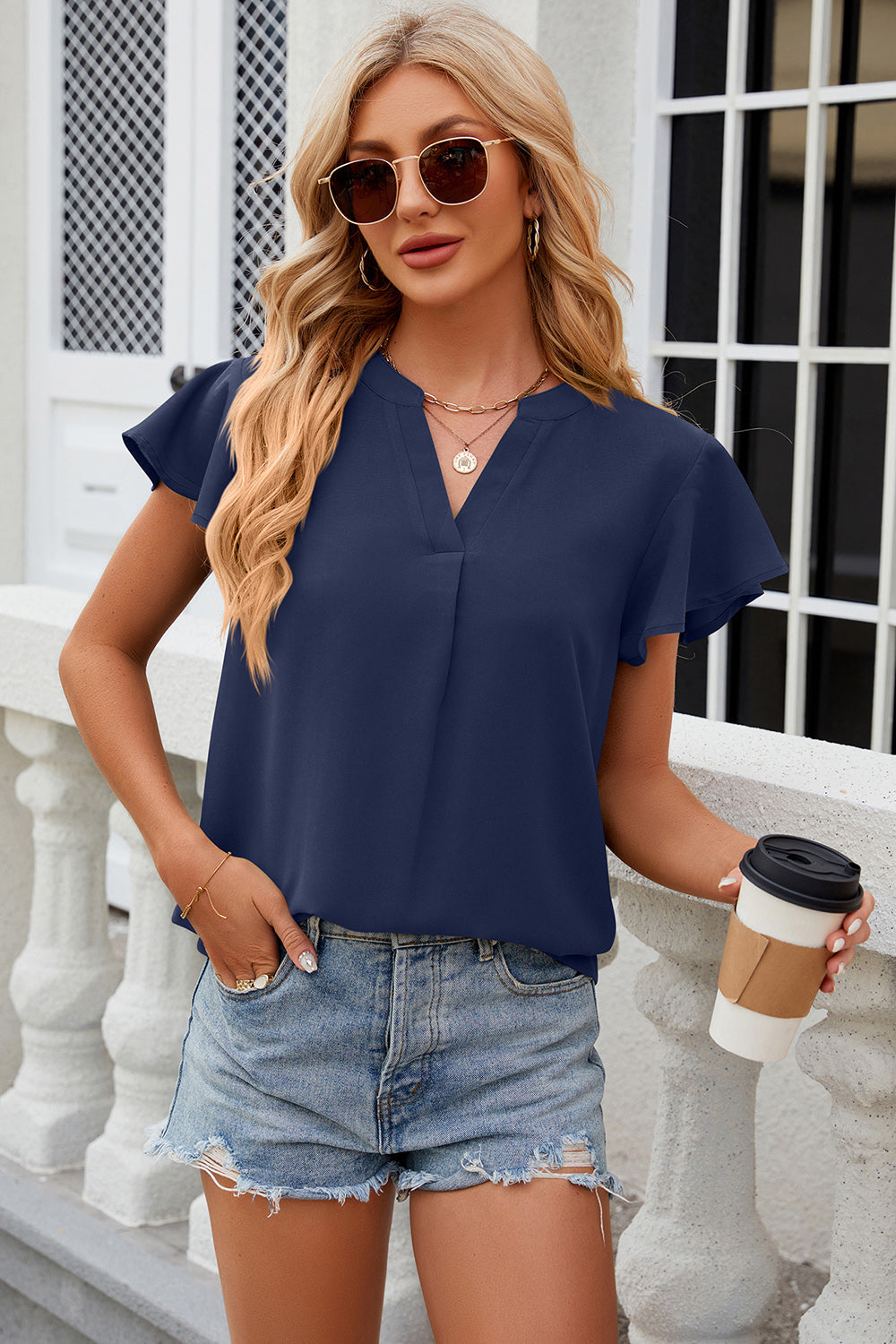 Dark blue flutter sleeve v-neck blouse with a relaxed fit.
