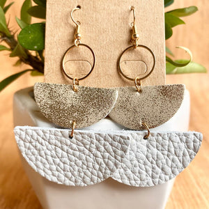 Textured leather half-moon earrings with metallic accents and gold hoops.