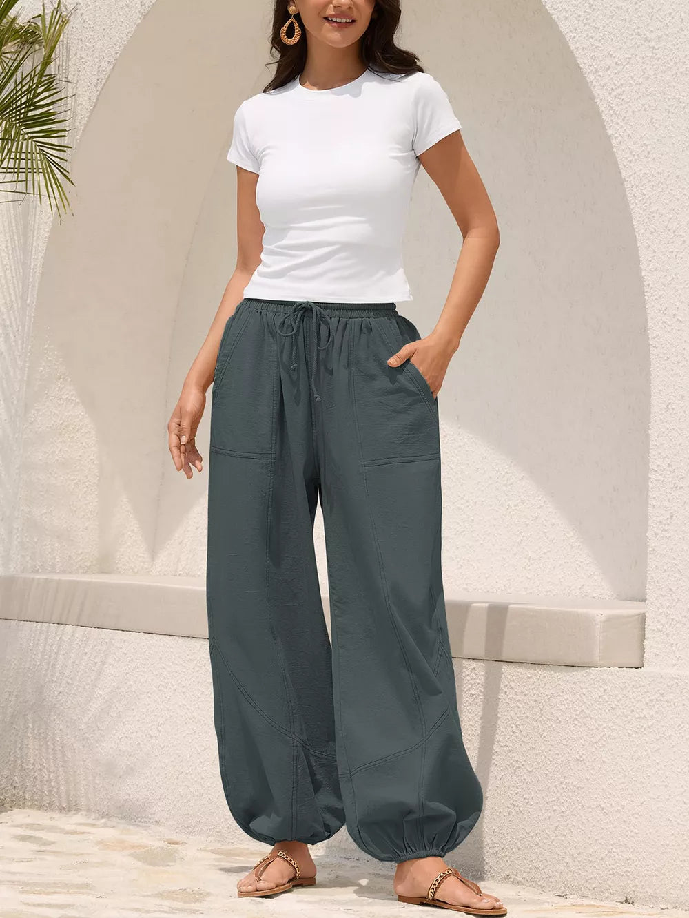 Grey relaxed harem pants with drawstring and contrast stitching detail.