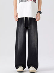 Oversized wide-leg jeans in black denim with drawstring waist and vintage wash.