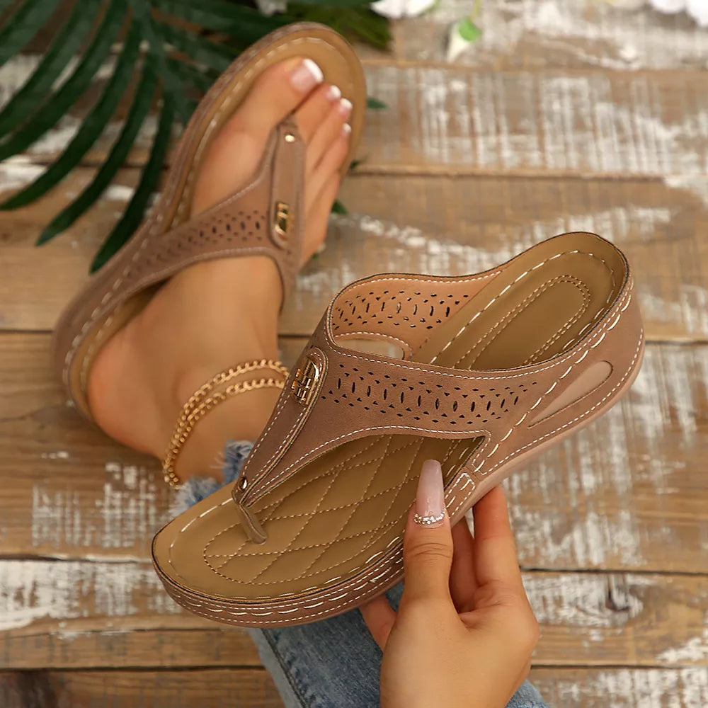 Khaki perforated leather wedge sandals with a thong strap and cushioned footbed.