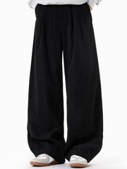 Men's black pleated wide leg trousers with a casual fit.