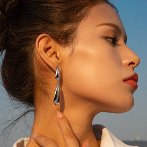 Silver teardrop dangle earrings with a polished finish.