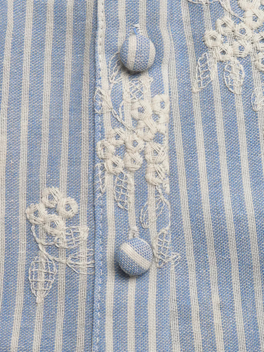 Blue and white striped peplum shirt with white floral embroidery and button details.