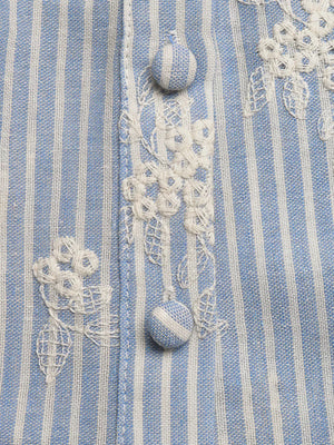 Blue and white striped peplum shirt with white floral embroidery and button details.