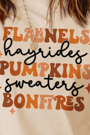Cream t-shirt with retro graphic text for autumn: flannels, hayrides, pumpkins, sweaters, bonfires.
