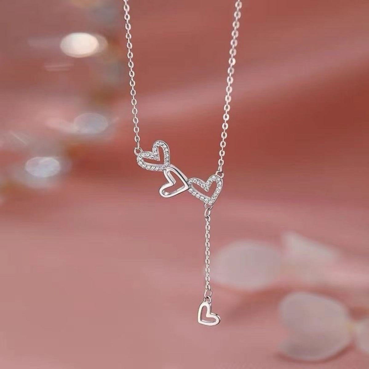Sterling silver Y-necklace with three sparkling heart charms, delicate chain.