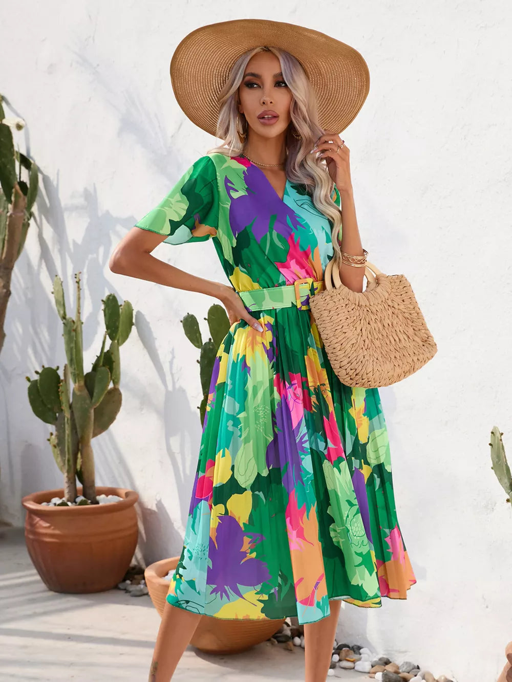 Tropical pleated midi dress in dark green with a vibrant floral print and matching belt.