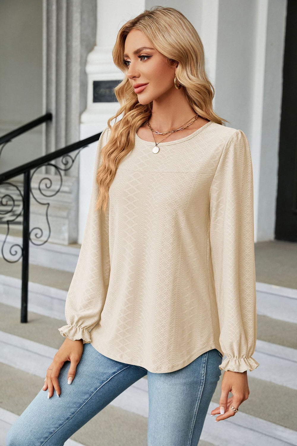 Textured cream puff sleeve blouse with ruffle cuffs and crew neck.