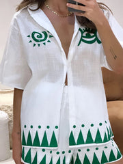 White linen co-ord set with green sun and geometric print, button-down shirt and shorts.