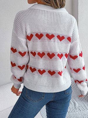 White knit polo sweater with red heart stripe pattern and long sleeves.