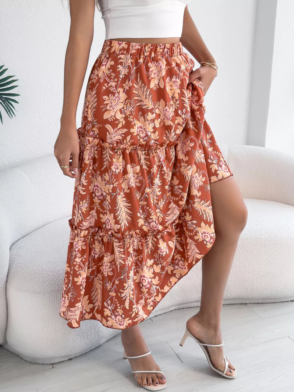 Orange floral midi skirt with tiered ruffles and asymmetrical hem.
