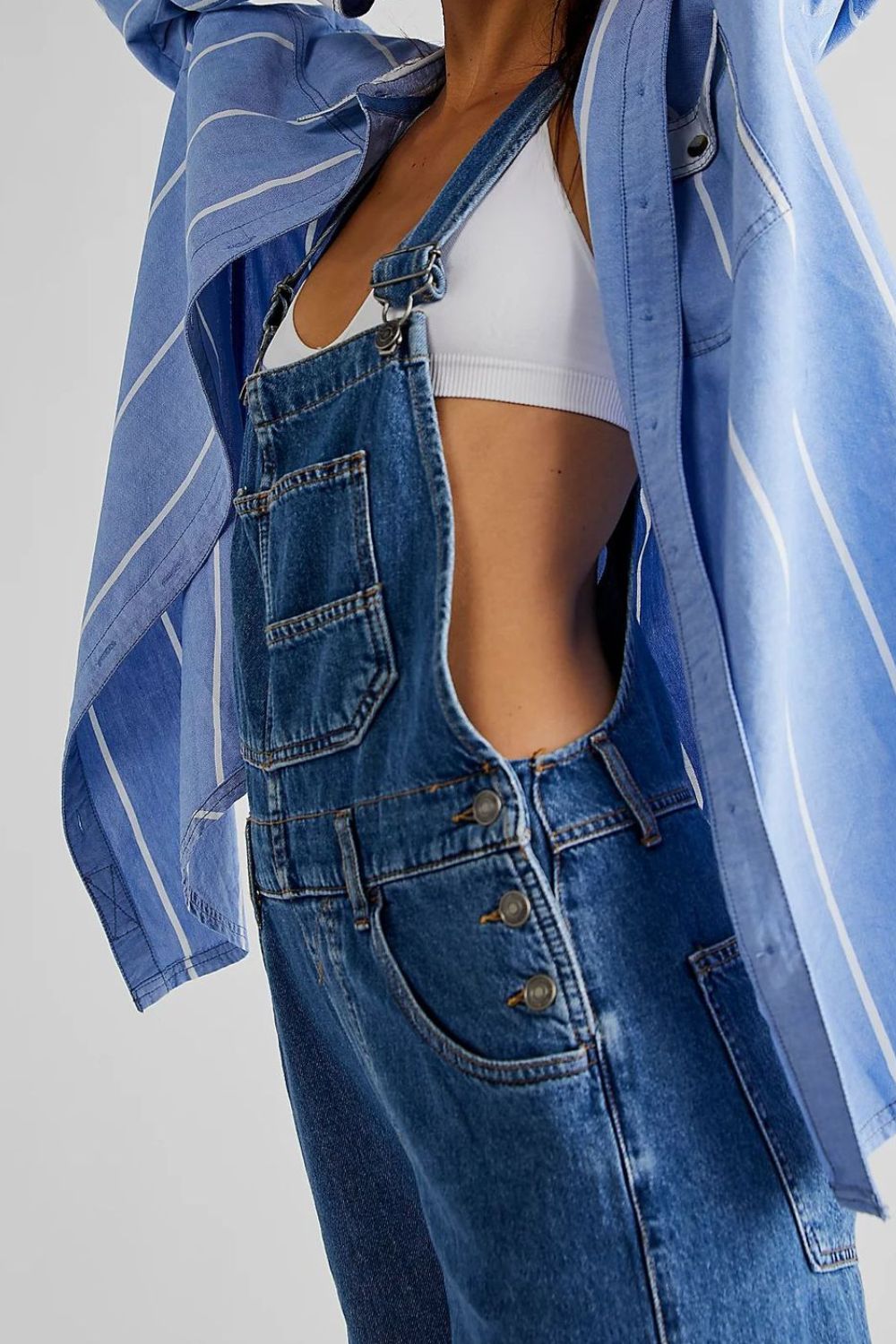 Relaxed fit denim overalls in medium wash with button closure and front pockets.