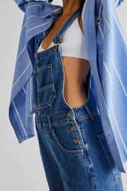 Relaxed fit denim overalls in medium wash with button closure and front pockets.