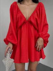 Scarlet ruched V-neck dress with balloon sleeves and textured fabric.